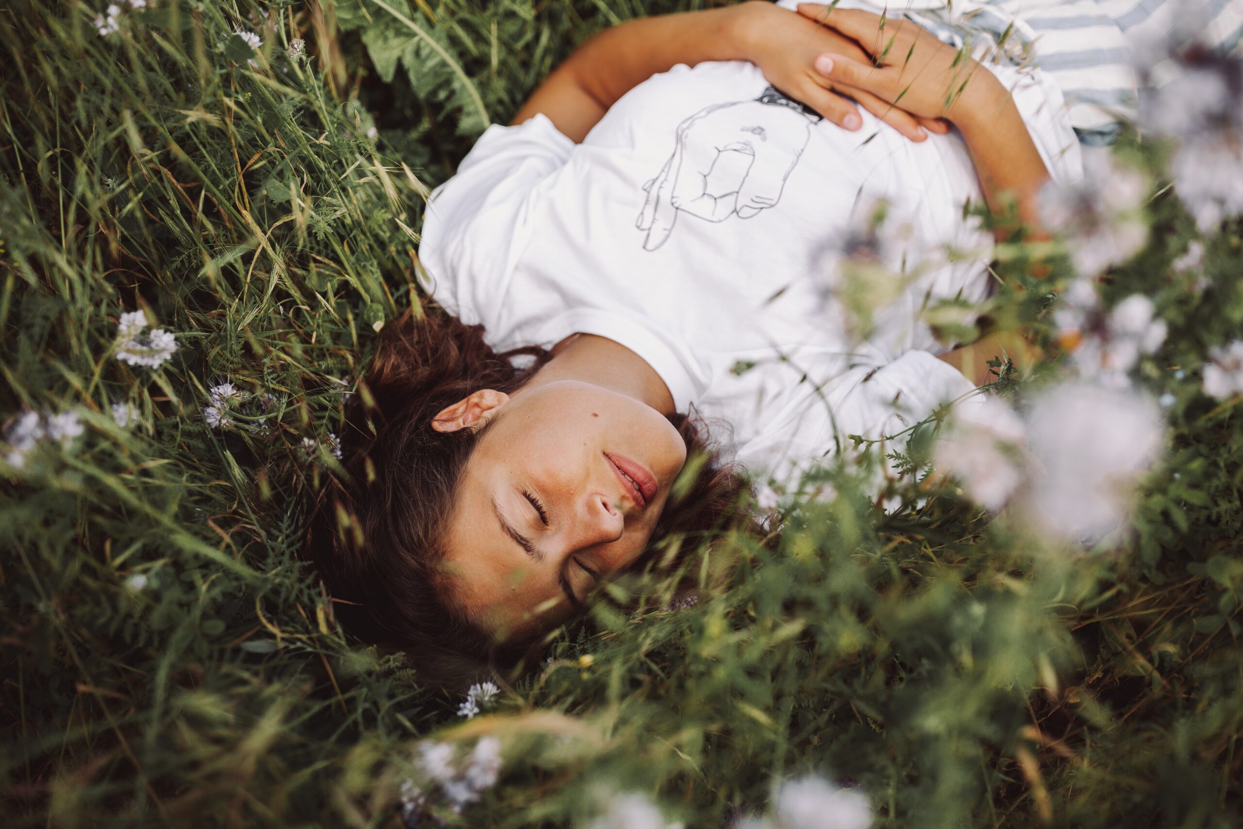 beautiful shot model laying down daisy field with her eyes closed