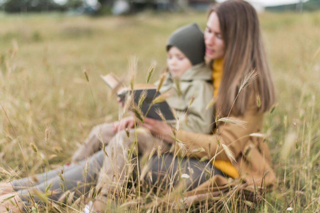 woman reading book his son outdoors